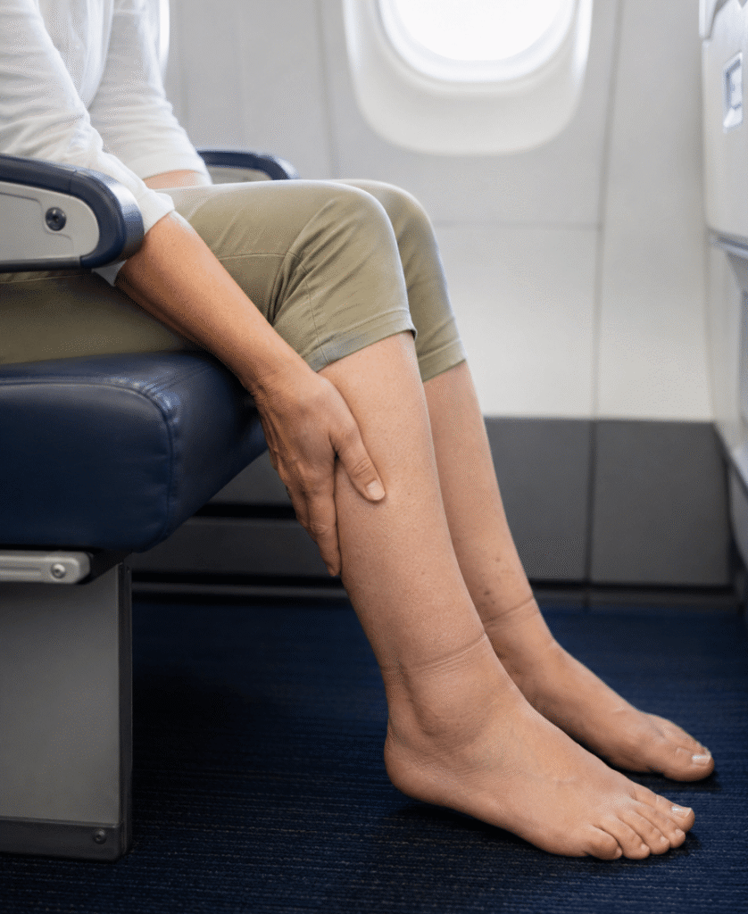 Persona sentada en un avión con molestias en la pierna durante un vuelo largo